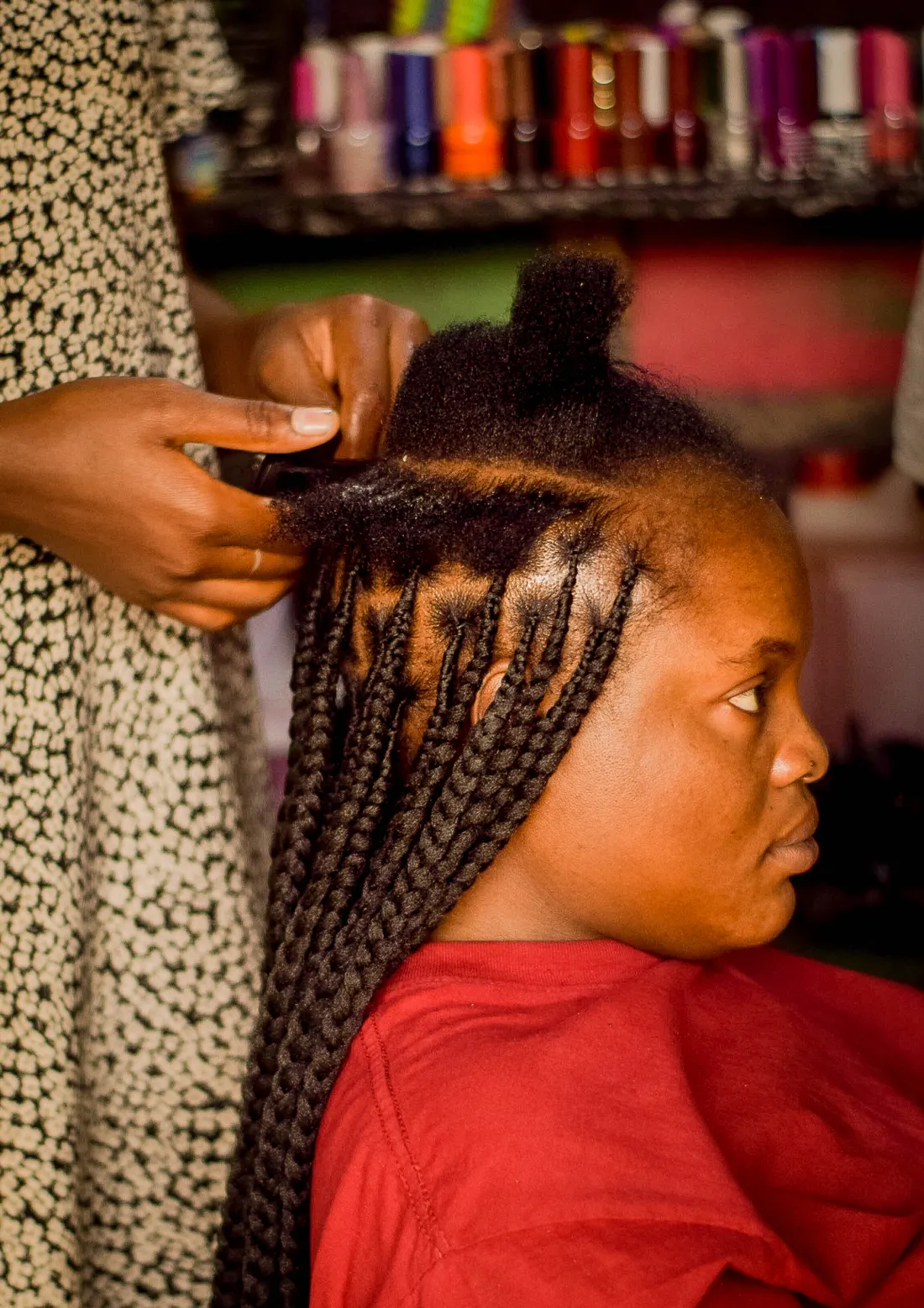 A stylist braiding a client's hair in a salon