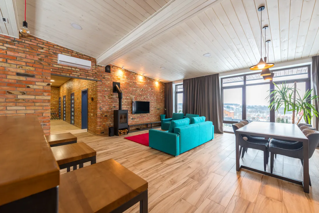 A finished modern living room with exposed brick